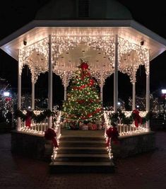 a gazebo covered in christmas lights with a tree