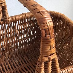 a brown wicker basket sitting on top of a white wall