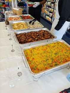 several trays of food are lined up on a table