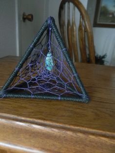 a triangle shaped object sitting on top of a wooden table