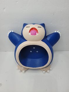 a blue and white stuffed animal with its mouth open