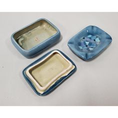 three blue and white dishes sitting on top of a table