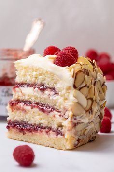 a piece of cake with raspberries and almonds on top