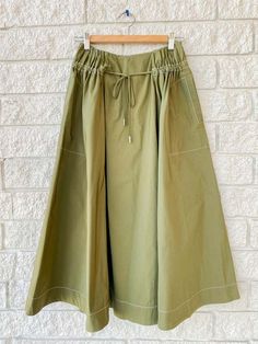 - simkhai tona midi skirt in army green  - midi length  - high waisted  - adjustable waist tie  - oversized patch pocket Khaki Flowy Skirt For Spring, Khaki Midi Skirt For Spring, Green Midi Bottoms With Elastic Waistband, Mother Denim, Knit Sweatshirt, Frame Denim, Outerwear Sweater, Ulla Johnson, Designer Outfits Woman