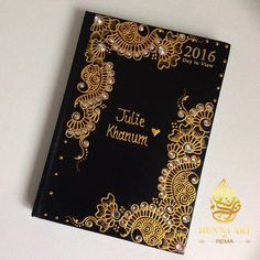 a black and gold wedding album on a white surface with the words juie karum written in arabic