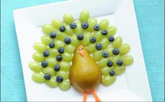 a plate with grapes on it and a turkey made out of grapes in the middle