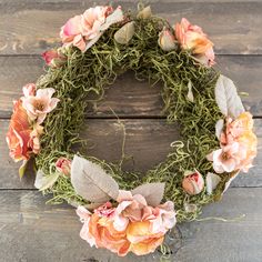 a wreath made out of moss and flowers on a wooden surface with the words diy spring wreath