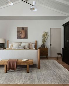 a bedroom with a large bed and two lamps on the ceiling, along with an area rug