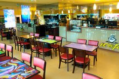 the inside of a restaurant with colorful tables and chairs