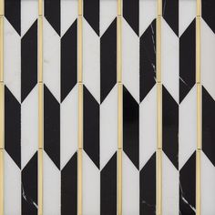 a black and white tiled wall with gold trim