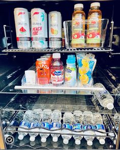 an open refrigerator filled with drinks and condiments on the shelf next to each other