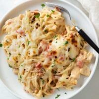 a white plate topped with pasta covered in sauce