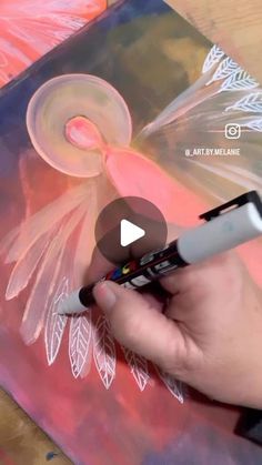 someone is painting an angel with acrylic paint on the canvas and using it as a marker