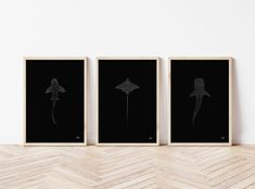 three black and white prints on a wall in an empty room with chevron wood flooring