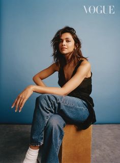 a woman sitting on top of a wooden box