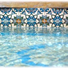 the water is running down the side of the wall with blue flowers on it's sides