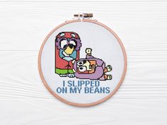 a cross stitch pattern with the words i slipped on my beans and an image of a cartoon character