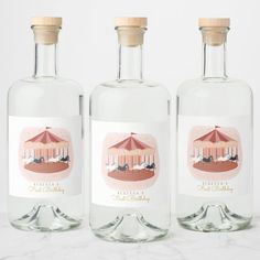 three bottles with labels on them sitting next to each other