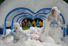 two children playing in foam and snow at an amusement park