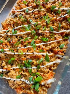 a casserole dish with carrots, onions and herbs on top in a glass pan