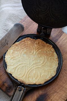 a cast iron skillet sitting on top of a wooden cutting board next to a knife