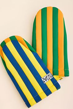 two oven mitts made to look like they have been painted in yellow, green and blue stripes