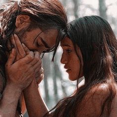 two women standing next to each other in the woods with their hands on their face