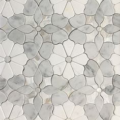 a close up view of a marble tile with white flowers and circles in the middle