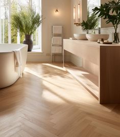 a bath room with a tub a sink and some plants in the window sill