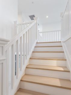 there is a white staircase with wooden handrails