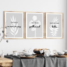 three framed art prints hanging on the wall above a table with plates and cups in front of them