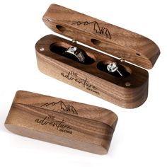 two wedding rings are in a wooden box with writing on the front and back sides