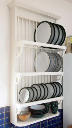 plates and bowls are stacked on a shelf