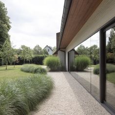 an outside view of a house with grass and bushes on the side of the building