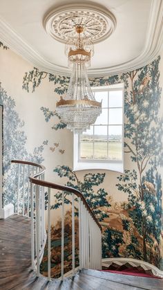 a chandelier hanging from the ceiling in front of a wallpapered room