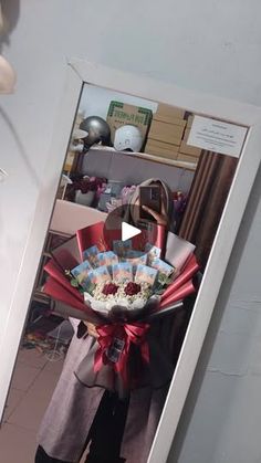 a woman holding a bouquet of flowers in front of a mirror