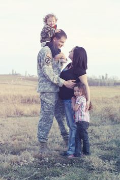 a man and woman with two children in a field