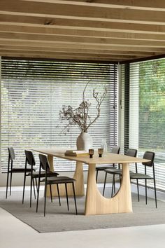 a table with chairs and a vase on it