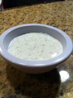 a white bowl filled with sauce sitting on top of a counter