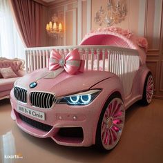 a pink car shaped like a baby's crib with a bow on it