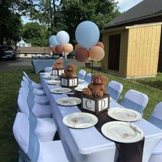 a table set up with plates and balloons for a teddy bear themed birthday party in the backyard