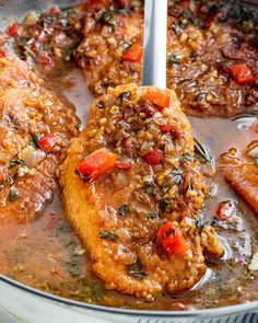 two pieces of meat in a pan with sauce and vegetables