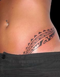 a woman's stomach with a tattoo design on the side and an arrow in the middle