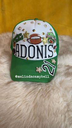 a green and white hat with footballs on it