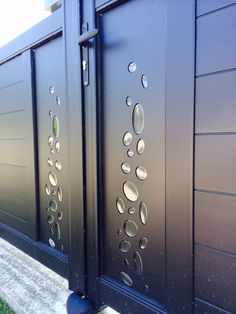 the side of a building with some metal circles on it's glass door panels