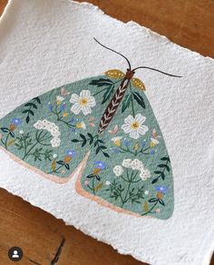 an image of a paper with a butterfly on it's back and some flowers in the background