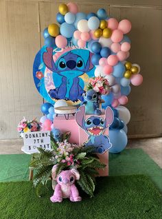 a birthday party with balloons, decorations and stuffed animals in front of the balloon wall