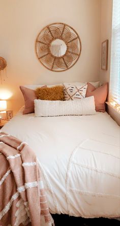 a white bed topped with pillows and blankets