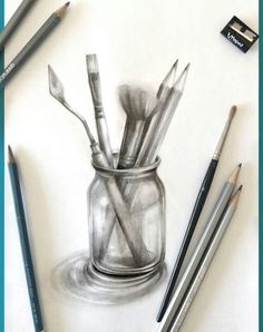 pencils and paintbrushes are sitting in a glass jar