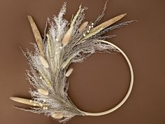 dried grass and feathers arranged in a circle on a brown background with copy - space